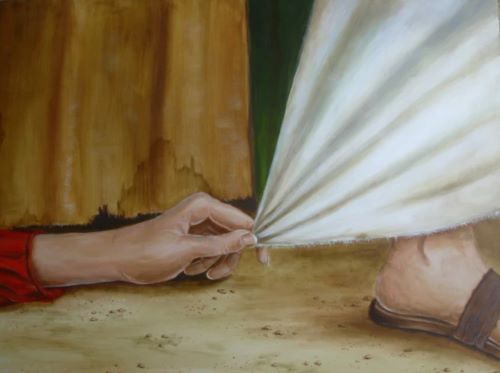 woman's hand reaching for the hem of Jesus cloak